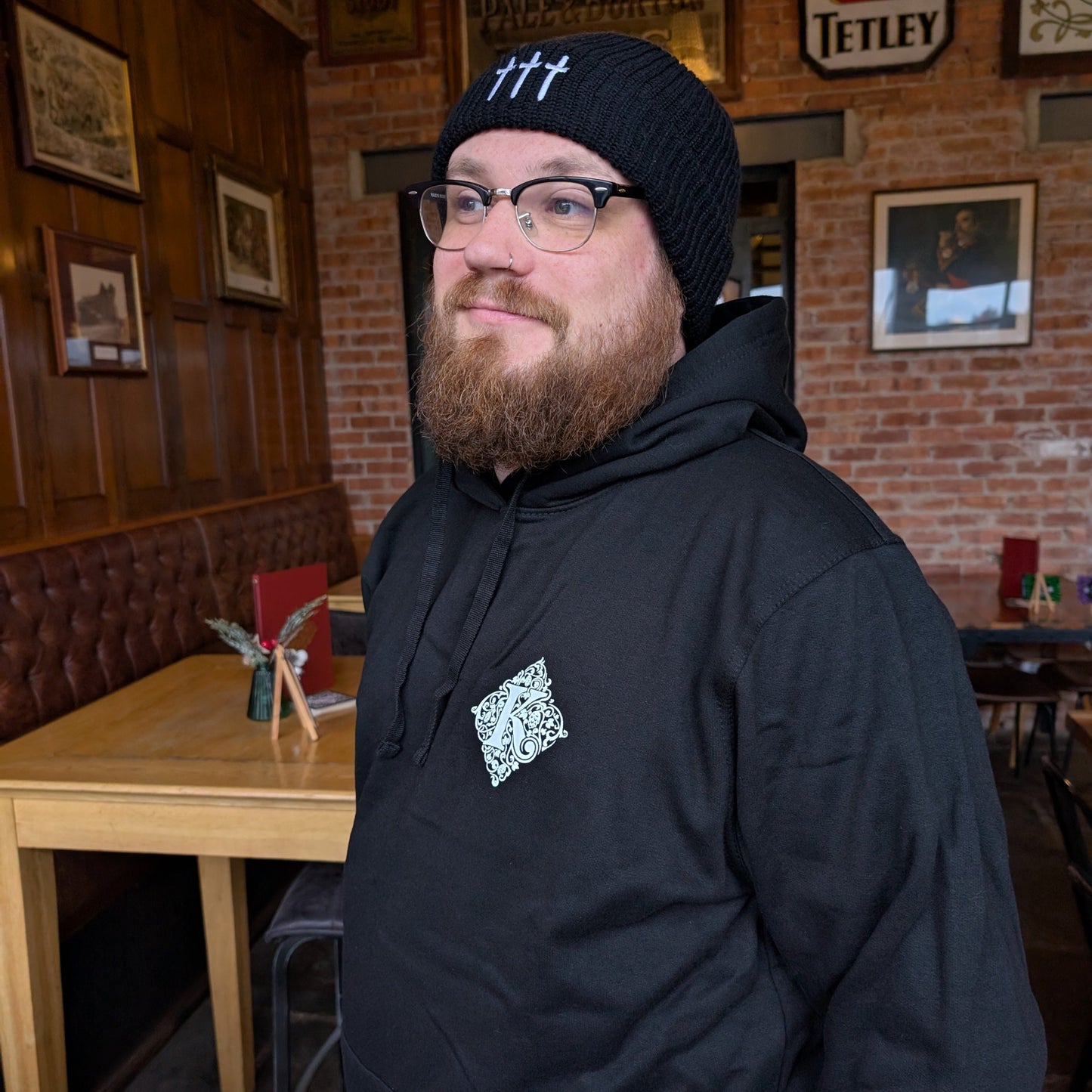 Man Wearing Kirkstall Logo Black Hoodie And Three Swords Beanie Hat