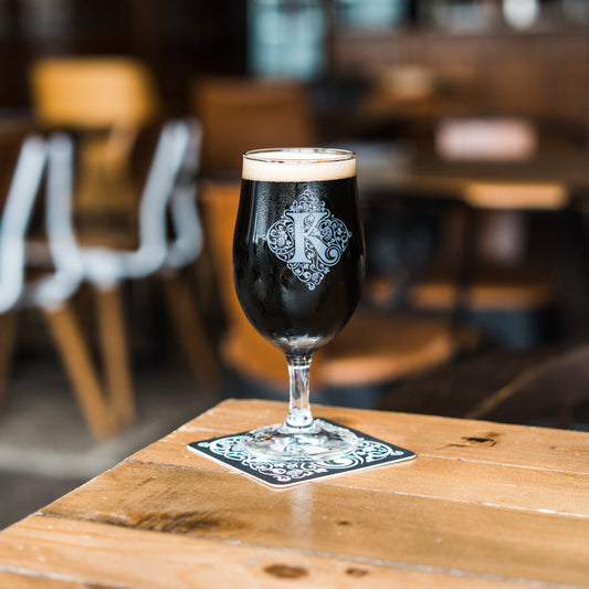 Kirkstall Logo Half Pint Glass On Table With Dark Beer