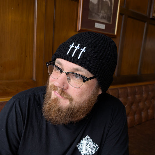 Man Wearing Three Swords Beanie Hat And Kirkstall Logo Black T-Shirt