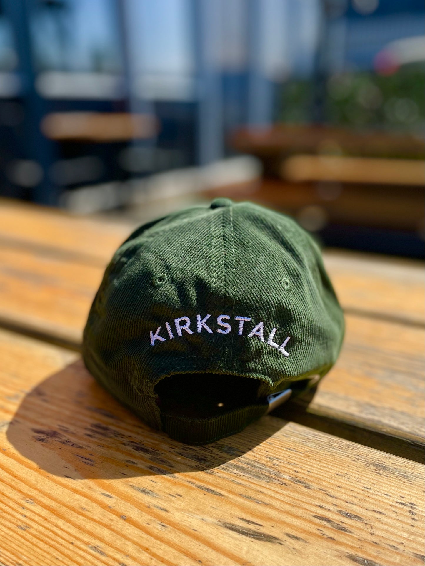 Virtuous Green Cap Back View With Kirkstall Branding On Table Outside