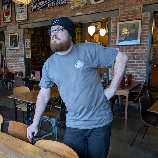 Man Leaning On Chair Wearing Grey Kirkstall T-Shirt