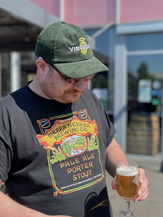 Man Wearing Virtuous Cap Holding Half Pint Outside